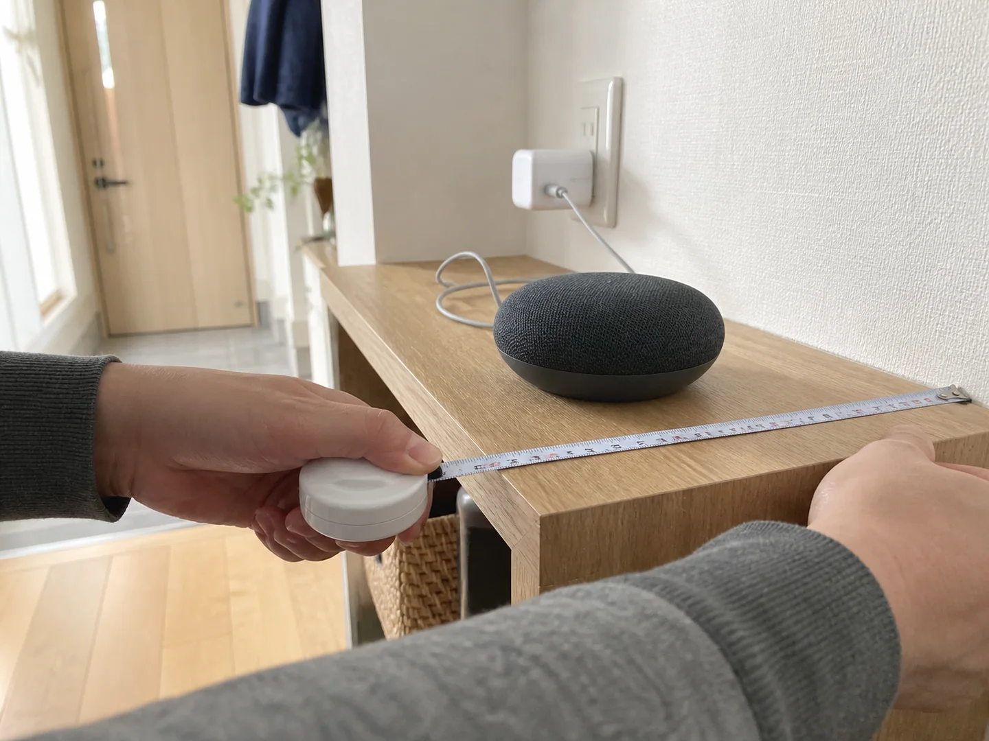 1LDKの棚で小型スマートスピーカーの置き場所を測るイメージ