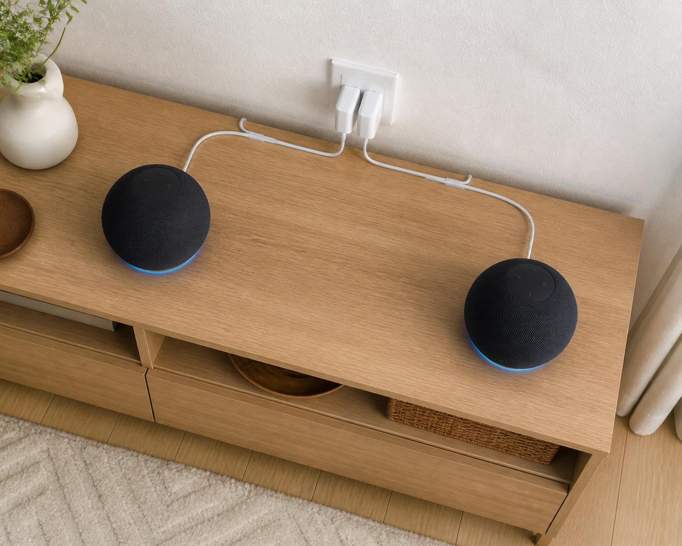木製コンソールの左右に置いた同じ形のスマートスピーカーと、背面へ沿わせた電源ケーブル